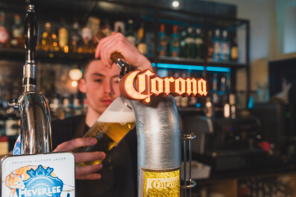 Man pouring a glass of Corona beer from a tap - casual dining enniskillen