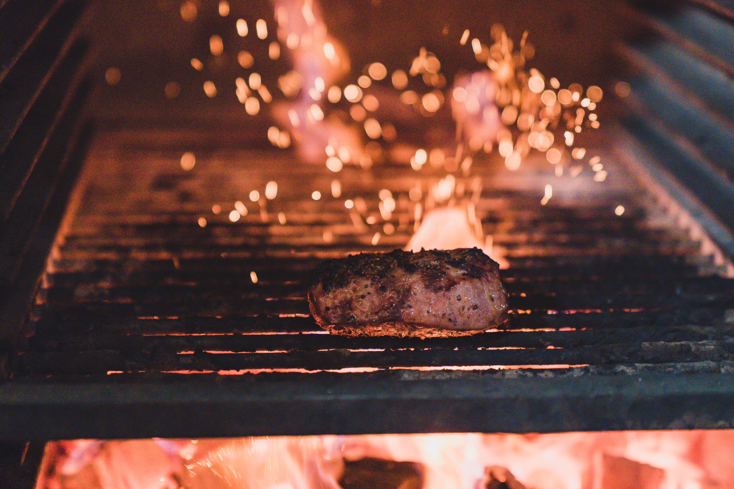 steak cooking on grill with flames. open fire cooking