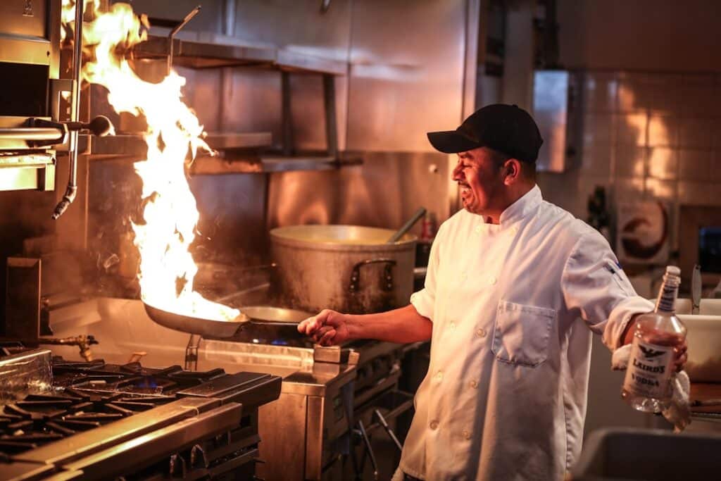 man in white chef uniform cooking - what to order at the firehouse